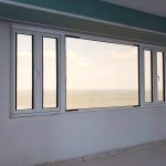 Ventana combinada fija y abatible con perfil bicolor serie COR-60. El PH se encuentra cerca del corredor, el vidrio insulado brinda la acusticidad que necesita el hogar.