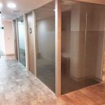 Sistema de divisiones con channel de aluminio y vidrio laminado, con puertas ciegas de apertura automática.